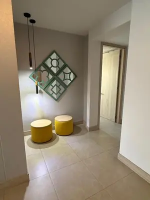 a room with two yellow stools and a painting on the wall at Serena del Mar, Morros IO in Cartagena de Indias