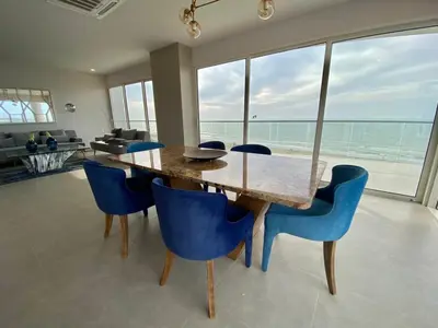 a dining room with a wooden table and blue chairs at Serena del Mar, Morros IO in Cartagena de Indias
