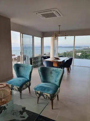 a living room with blue chairs and a table with a view at Serena del Mar, Morros IO in Cartagena de Indias