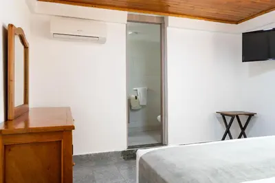 a bedroom with a bed and a glass shower at Hotel Corozal Plaza in Corozal