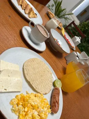 a table topped with plates of breakfast foods and drinks at Hotel Corozal Plaza in Corozal