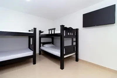a room with three bunk beds and a flat screen tv at Playa Norte Hotel in Cartagena de Indias