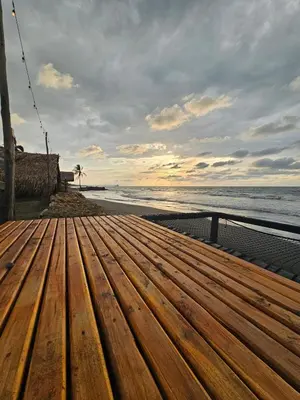 a wooden bench on a beach with the ocean at AGUAMARINA House in San Bernardo del Viento