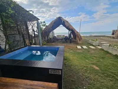 a hot tub in a yard with a view of the ocean at AGUAMARINA House in San Bernardo del Viento