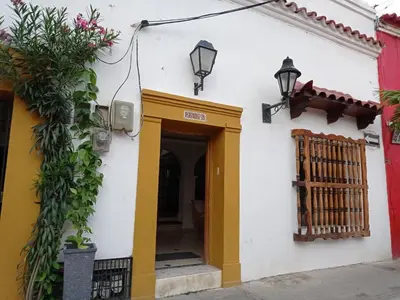 a building with a yellow door and a gate at La 10B in Cartagena de Indias