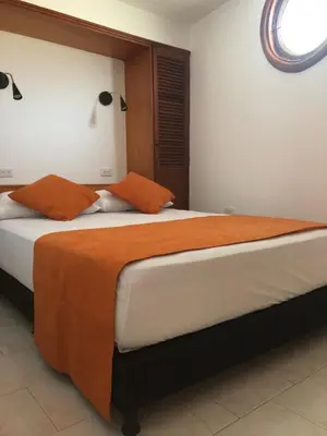 a bedroom with two beds with orange and white sheets at La 10B in Cartagena de Indias