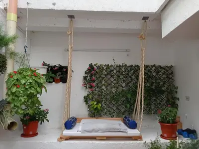 a porch swing with a bed and potted plants at La 10B in Cartagena de Indias