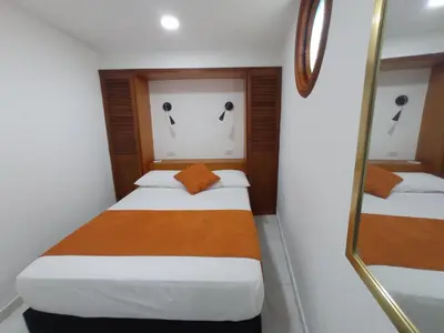 a small room with two beds and a mirror at La 10B in Cartagena de Indias