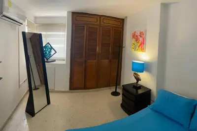 a bedroom with a blue bed and a blue lamp at Oferta frente a la playa Cartagena . En, Sp, It. in Cartagena de Indias