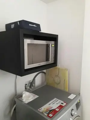 a microwave sitting on top of a refrigerator at Rincon 94- Barranquilla- Rio Alto in Barranquilla