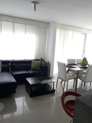 a living room with a black couch and a table at Rincon 94- Barranquilla- Rio Alto in Barranquilla