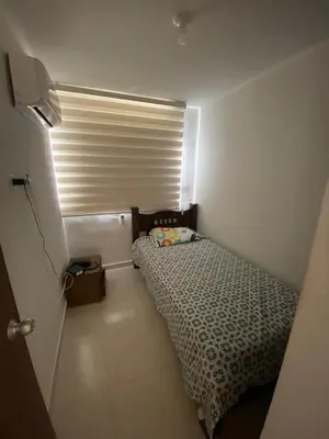 a small room with a bed and a window at Torino Barranquilla- Miramar in Barranquilla