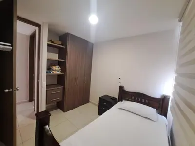 a bedroom with a bed and a wooden cabinet at Torino Barranquilla- Miramar in Barranquilla