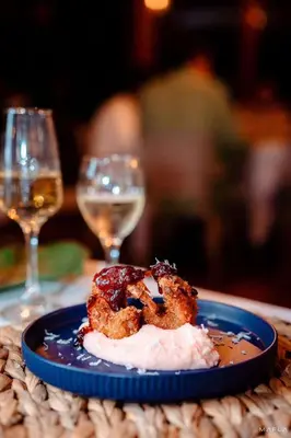 a plate of food on a table with wine glasses at Rosario EcoHotel - Islas del Rosario in Isla Grande