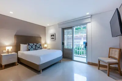 a bedroom with a bed and a tv and a window at Apartamentos casa Gimani in Cartagena de Indias