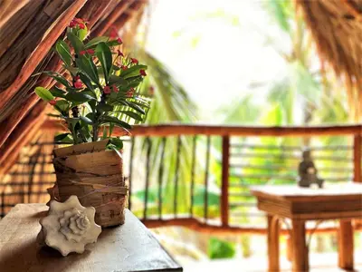 a vase with flowers on a table next to a balcony at Isla Fuerte - Wiji Island House in Isla Fuerte