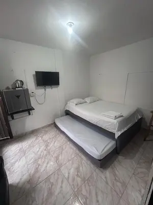 a small room with two beds and a tv at Sophia House in Cartagena de Indias