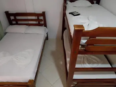 a small room with two bunk beds and a table at Hotel El Puerto in Tolú