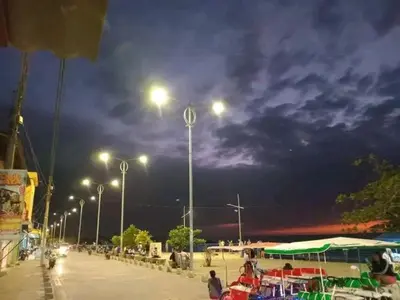 a parking lot at night with street lights and people at Hotel El Puerto in Tolú