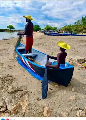 two people in a blue boat on a beach at Hotel El Puerto in Tolú