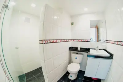 a white bathroom with a toilet and a sink at Apartamento Lorenita in Cartagena de Indias