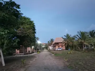 a dirt road in front of a house at Palmar del viento cabaña frente al mar in Moñitos