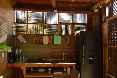 a kitchen with a black refrigerator and a counter at Palmar del viento cabaña frente al mar in Moñitos