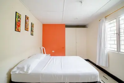 a white bed in a room with a window at HABITACION PRIVADA EN CASA DE MIS PADRES in Barranquilla