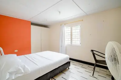 a bedroom with a bed and a window and a chair at HABITACION PRIVADA EN CASA DE MIS PADRES in Barranquilla
