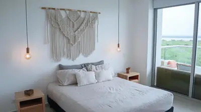 a white bedroom with a bed and a large window at MORROS EPIC 1 ALCOBA VISTA CIENAGA in Cartagena de Indias