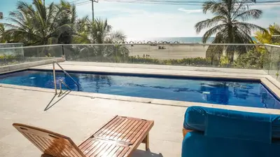a swimming pool with a chair and a beach at MORROS EPIC 1 ALCOBA VISTA CIENAGA in Cartagena de Indias
