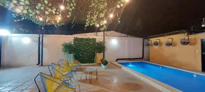 a swimming pool with chairs and a table next to at CABAÑA LAS MARIAS, Climatizada, Piscina y BBQ in Santa Marta