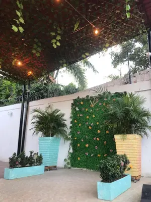 a wall with plants and flowers on it at CABAÑA LAS MARIAS, Climatizada, Piscina y BBQ in Santa Marta