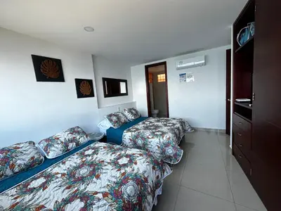 a hotel room with two beds and a bedskirts at Apartamento con vista al mar piso 19 Bocagrande in Cartagena de Indias