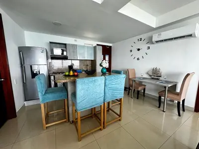 a kitchen with a table and a clock on the wall at Apartamento con vista al mar piso 19 Bocagrande in Cartagena de Indias