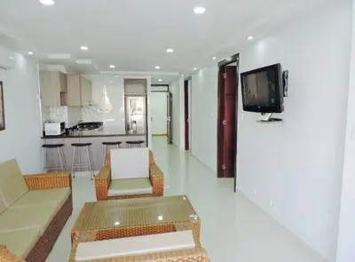 a living room with a couch and a tv on a wall at Cristoforo Oasis in Cartagena de Indias