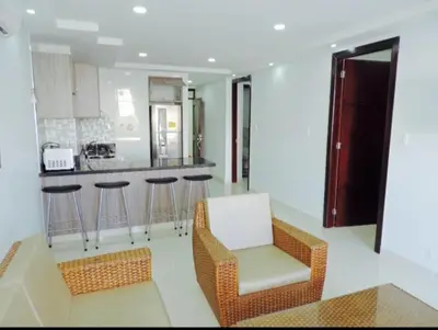 a kitchen with a chair and a bar with stools at Cristoforo Oasis in Cartagena de Indias