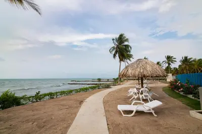 two chairs and an umbrella on the beach at Hermoso Apartamento Frente al Mar 2 Habitaciones PAZ122 in Coveñitas
