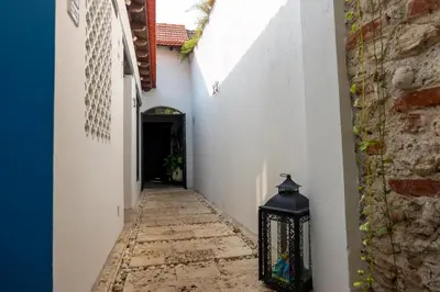 an alley with a black lantern in a white building at Casa Familiar - Maria de las Palmas -Getsemani in Cartagena de Indias