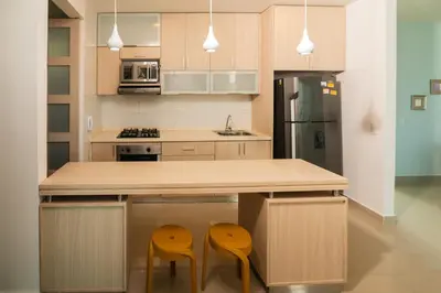 a kitchen with two yellow stools at a counter at Magico Apartamento Frente al Mar 3 Habitaciones AR33 in Coveñas