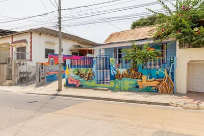 a blue building with a mural on it on a street at Mango Tree Hostel CTG 420 in Cartagena de Indias