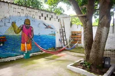 a mural of a man washing a wall with a hose at Mango Tree Hostel CTG 420 in Cartagena de Indias
