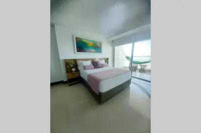 a bedroom with a bed and a large window at Caminando hacia la playa in Cartagena de Indias
