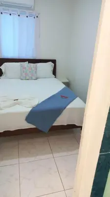 a bed with a blue blanket on it in a room at Tita’s Airport Hotel in Cartagena de Indias