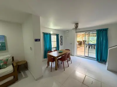a living room with a dining room table and a window at Cabana Costa Azul in Coveñas