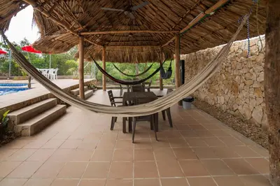 a hammock in a building with a table and chairs at Cabana Costa Azul in Coveñas