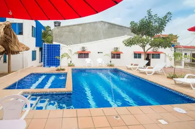 a pool in front of a house with an umbrella at Cabana Costa Azul in Coveñas
