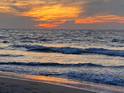 a sunset on the beach with the ocean at Edificio frente al mar con playas tranquilas in Cartagena de Indias