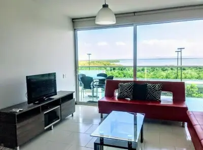 a living room with a red couch and a flat screen tv at Edificio frente al mar con playas tranquilas in Cartagena de Indias
