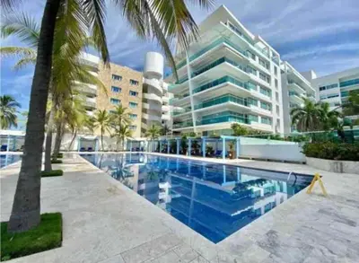 a swimming pool in front of a large building at Edificio frente al mar con playas tranquilas in Cartagena de Indias